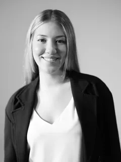 Black and white portrait of Candidate Appraiser Ashley Bradish, smiling, in a dark blazer