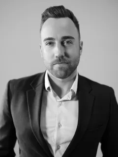 Black and white portrait of Colin Abbot, Director of Operations, in a dark blazer