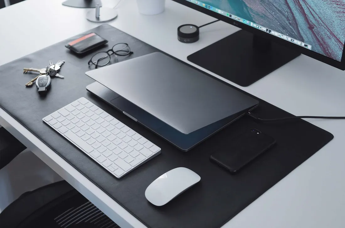 A tidy desk with a laptop, keyboard and documents, ready for review